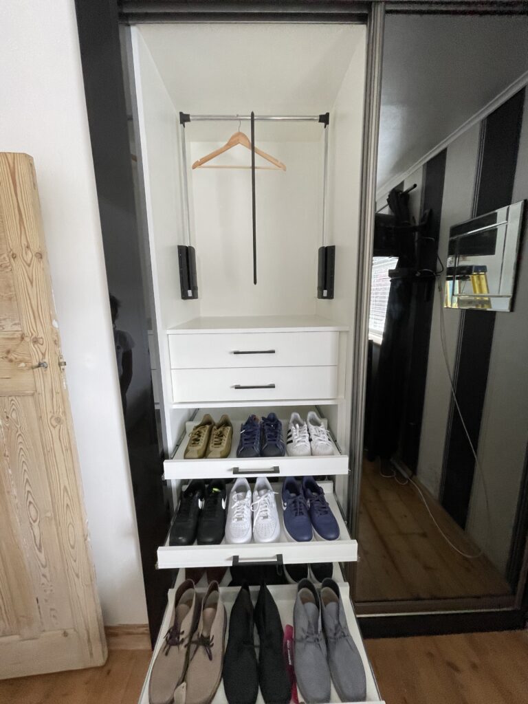 Completed bespoke storage with pull-down hanging rail and fitted shoe drawers