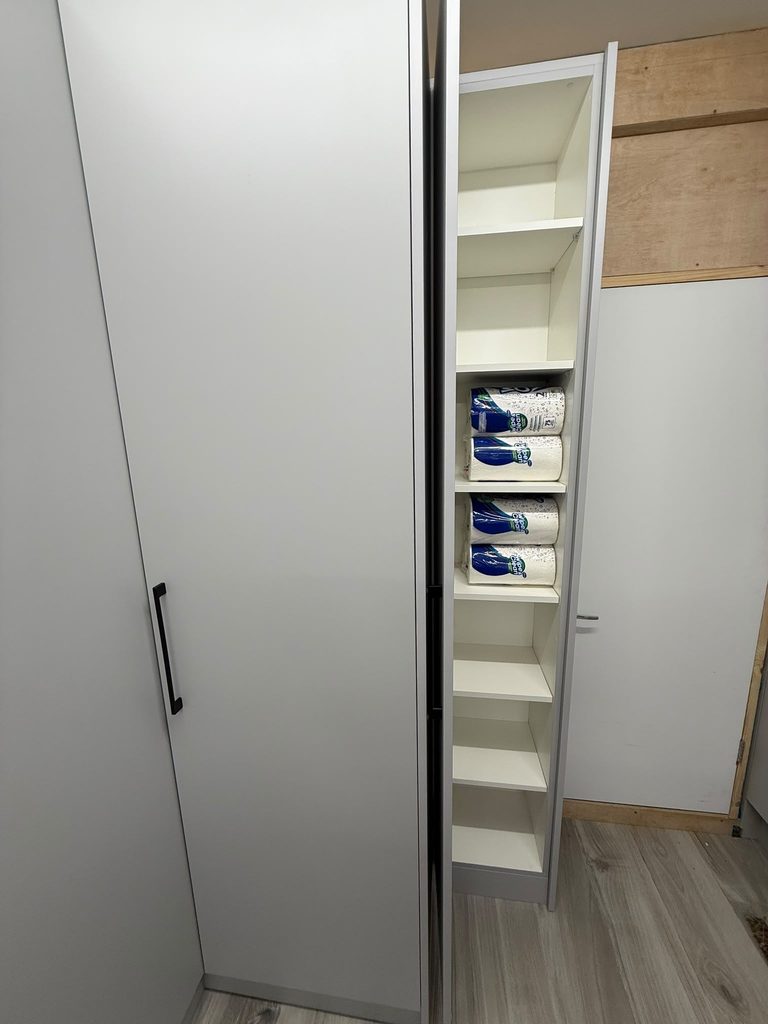 Floor-to-ceiling bespoke garage storage cabinets with clean grey doors and black handles installed in St Albans